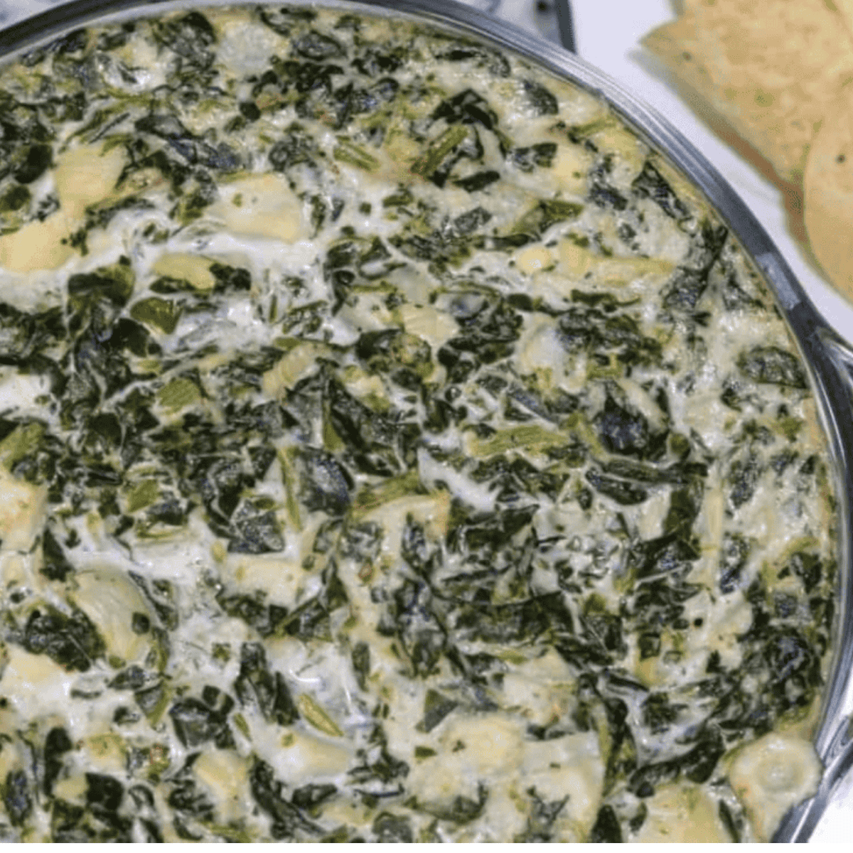 A bowl of creamy Instant Pot Copycat Applebee’s Spinach and Artichoke Dip, ready to serve with chips or bread for dipping.