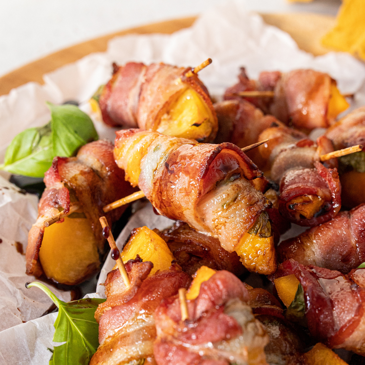 Air Fryer Bacon Wrapped Peaches with crispy bacon and juicy peach slices, served as a savory-sweet appetizer.