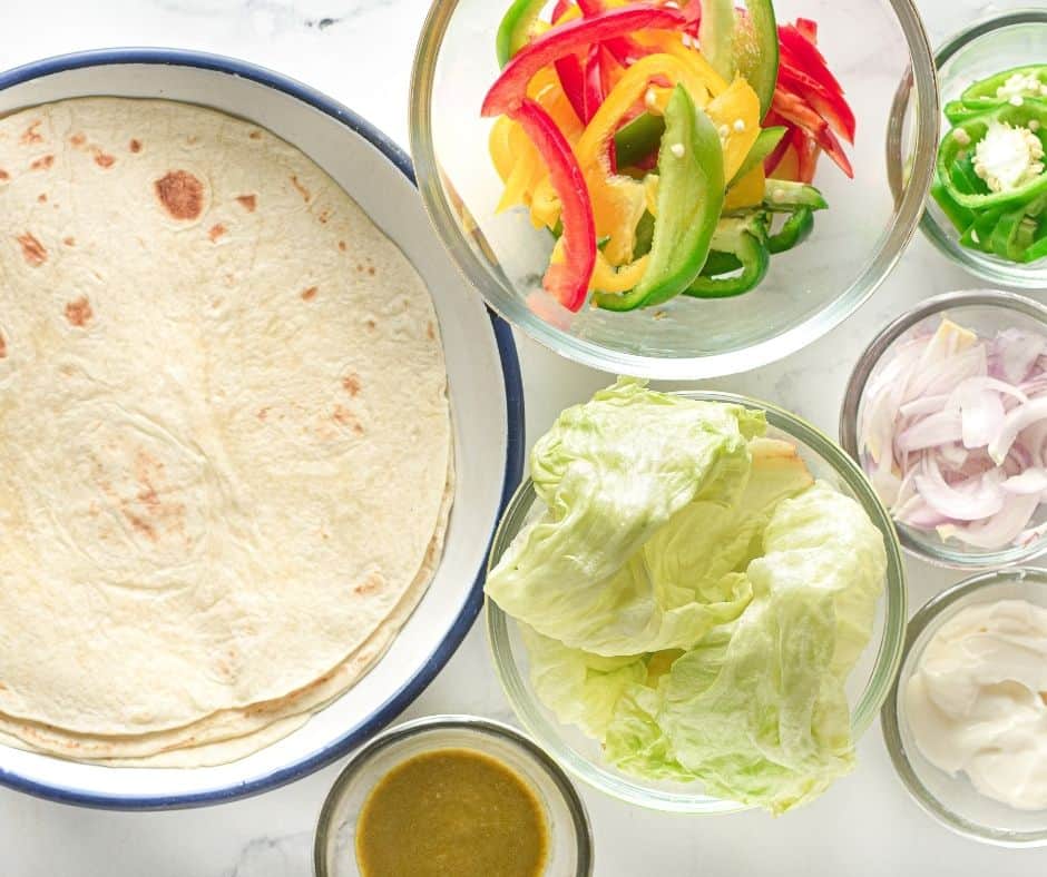 Assembling the Chicken Tikka Tortilla Wraps on kitchen table.