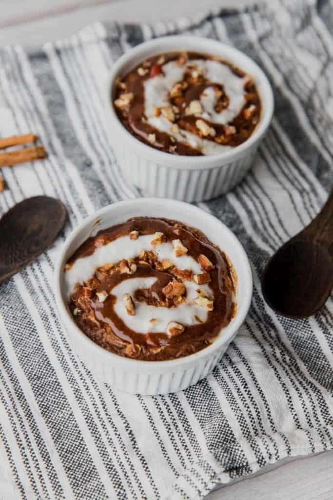 Finished cinnamon roll baked oatmeal styled with mixing spoons and whole cinnamon sticks