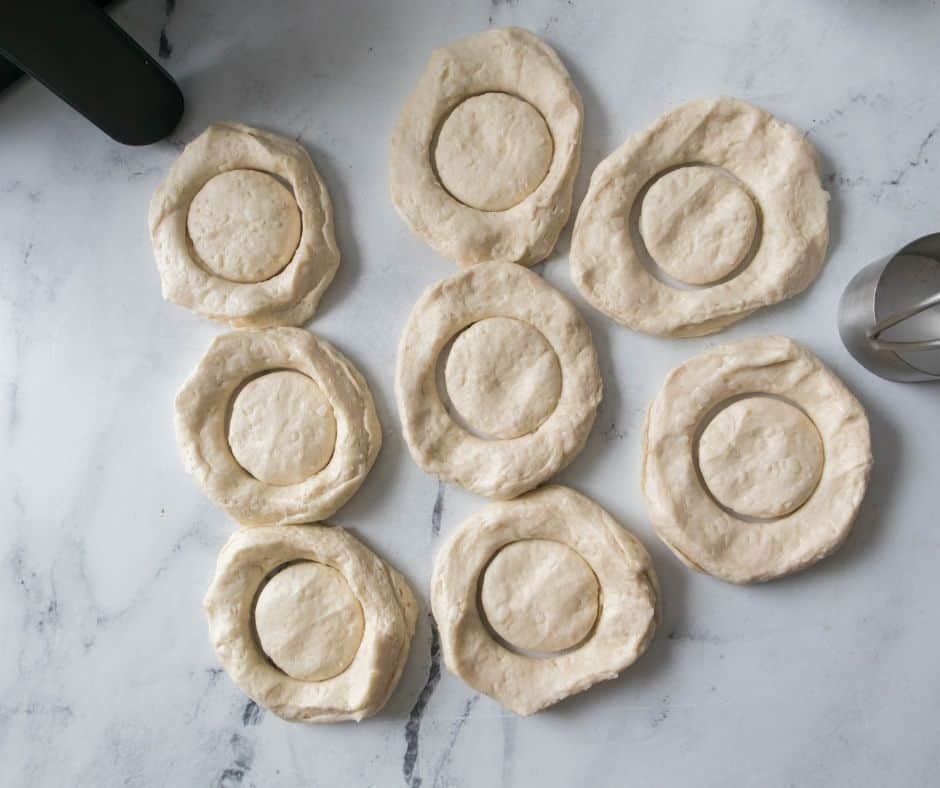 Use a biscuit cutter to cut the dough. Keep the centers for mini donuts or donut holes.