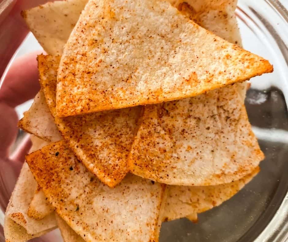 Mixing seasonings and coating tortilla wedges before air frying.