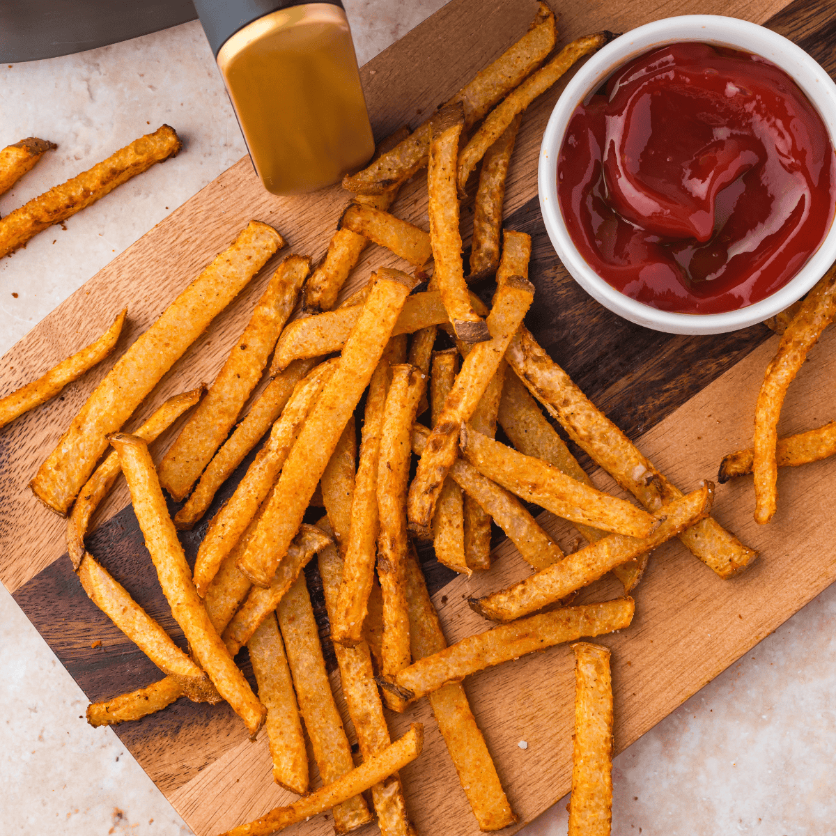 Crispy jicama fries in air fryer basket with smoky paprika seasoning.