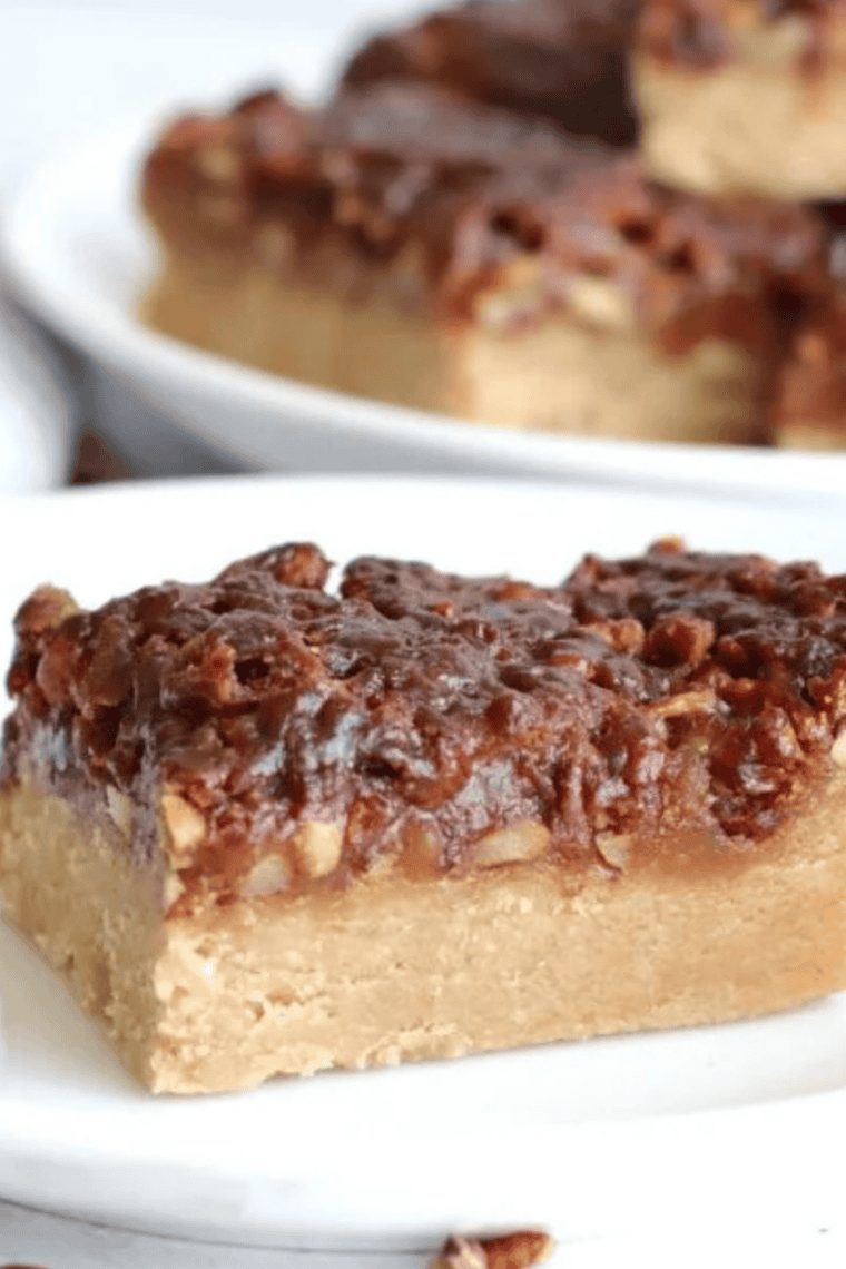 A stack of sliced Air Fryer Maple Pecan Bars showing a thick, golden shortbread base topped with a glistening layer of caramelized maple filling and crunchy toasted pecan halves.