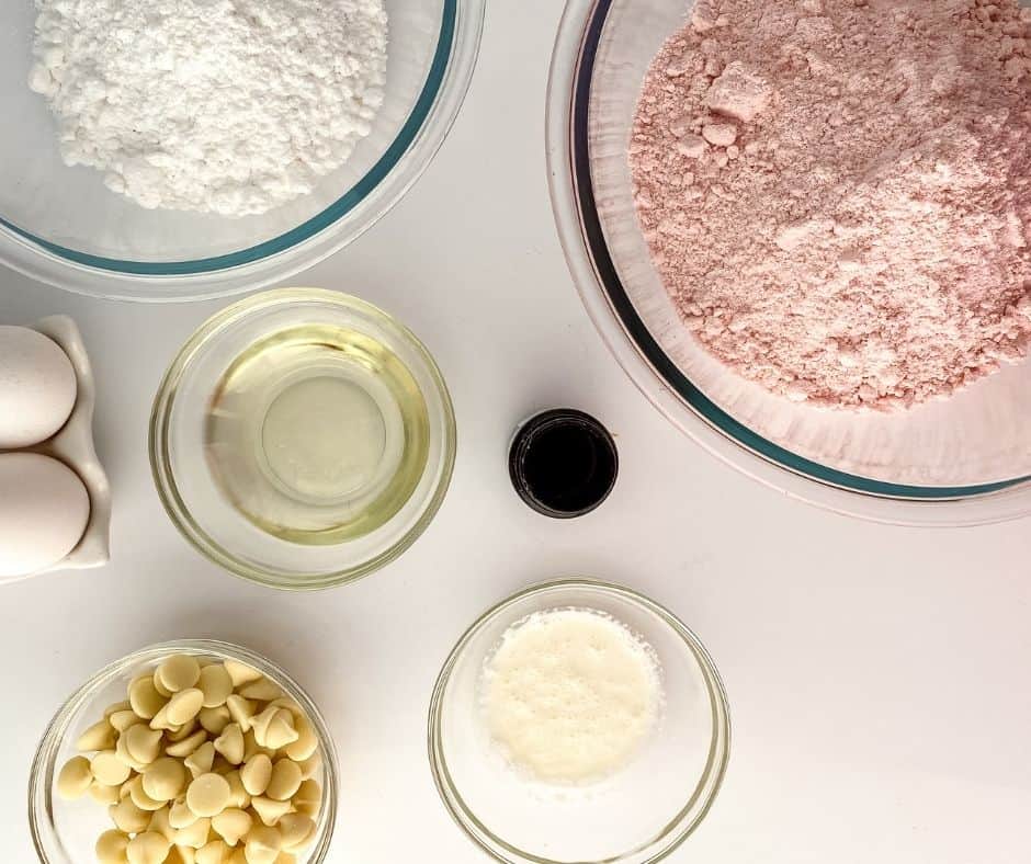 Ingredients for air fryer strawberry blondies: strawberry cake mix, eggs, oil, white chocolate chips and fresh strawberries