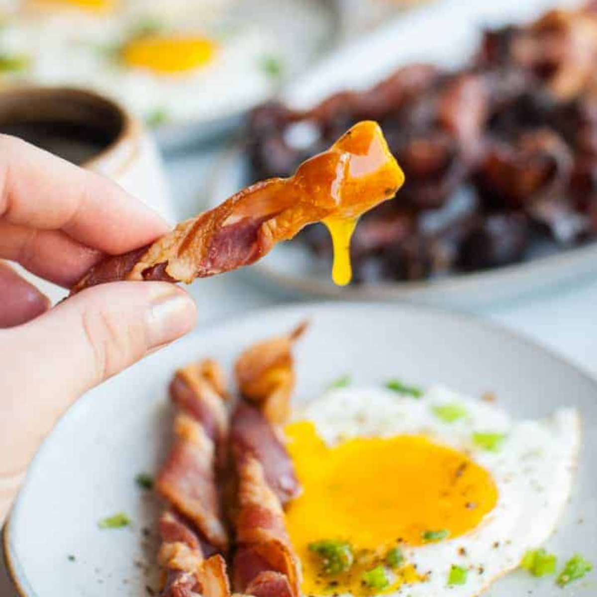 Plate of Air Fryer Twisted Candied Bacon, showcasing crispy, caramelized bacon twists with a glossy, sweet glaze.