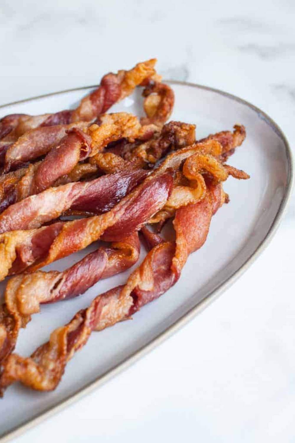 A plate of Air Fryer Twisted Candied Bacon, beautifully arranged and glistening with a sweet caramelized glaze, ready to be enjoyed as a delicious treat.
