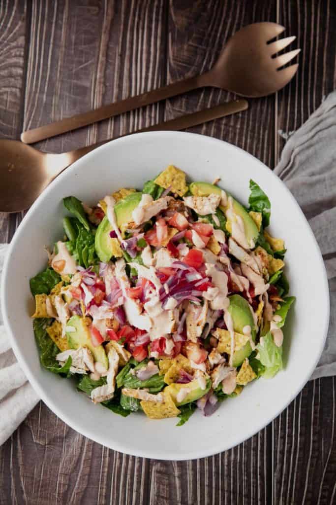 Tossing romaine and vegetables for Santa Fe Chicken Salad in a mixing bowl