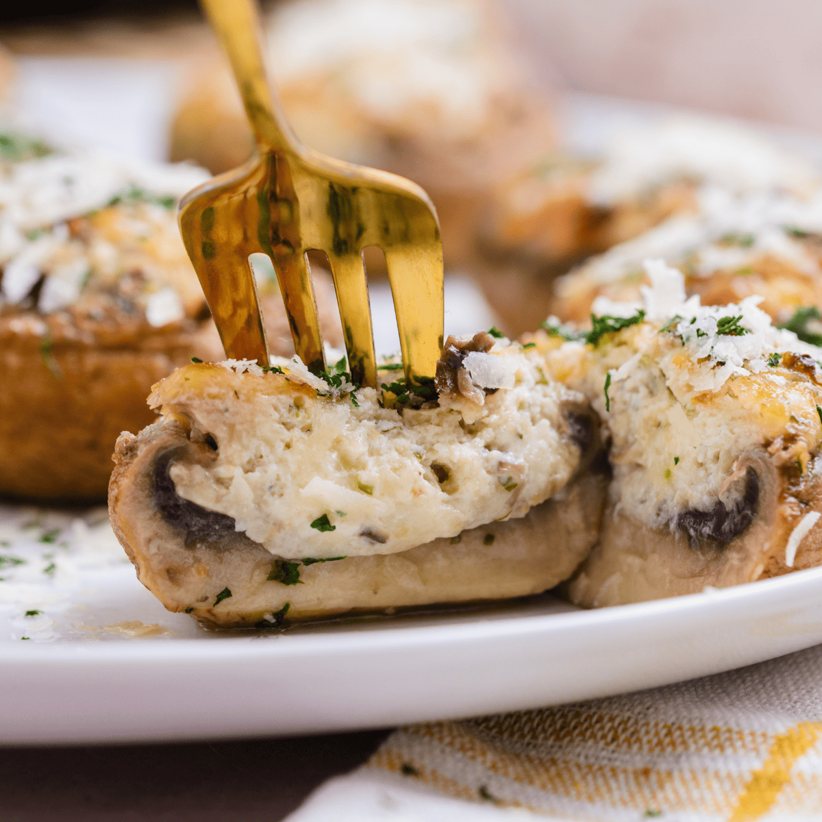 Copycat Longhorn stuffed mushrooms topped with golden, crispy white cheddar, served on a white plate