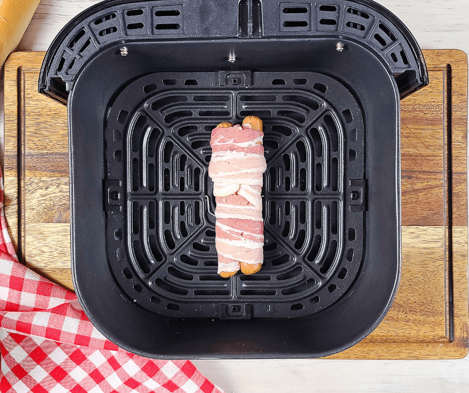 Image of hot dogs cooking in the air fryer: "Air Fryer cooking Carolina-Style Hot Dogs for a crispy finish."