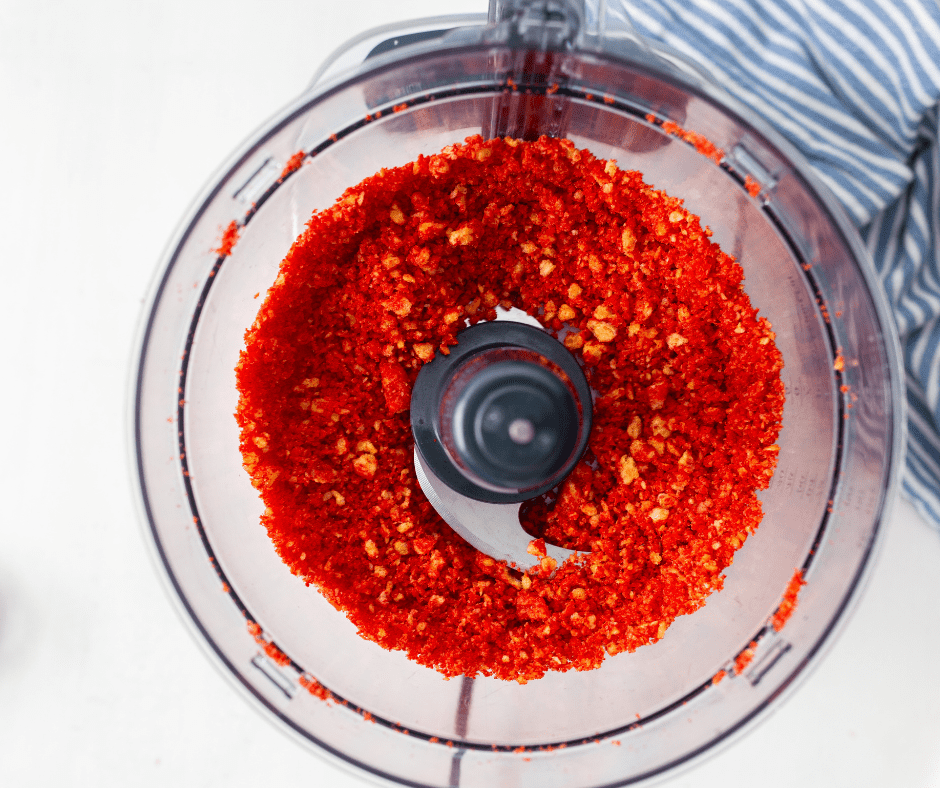 Crushing a handful of Takis into small pieces for coating the mozzarella sticks.