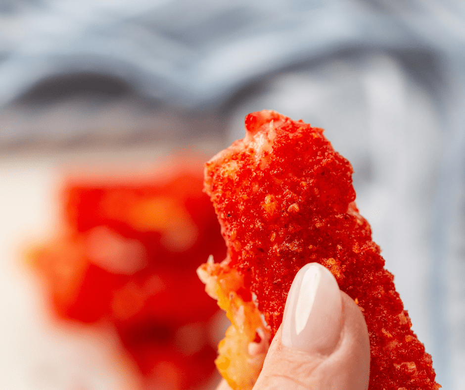 Plate of crispy Air Fryer Takis Mozzarella Sticks with a crunchy Takis coating.