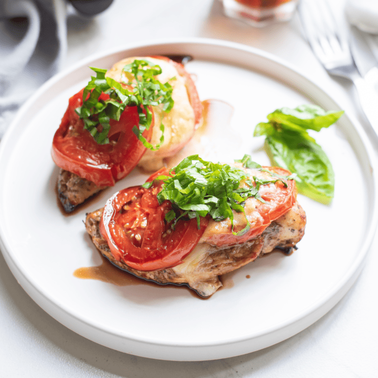 Close-up of caprese chicken with fresh mozzarella and tomato slices