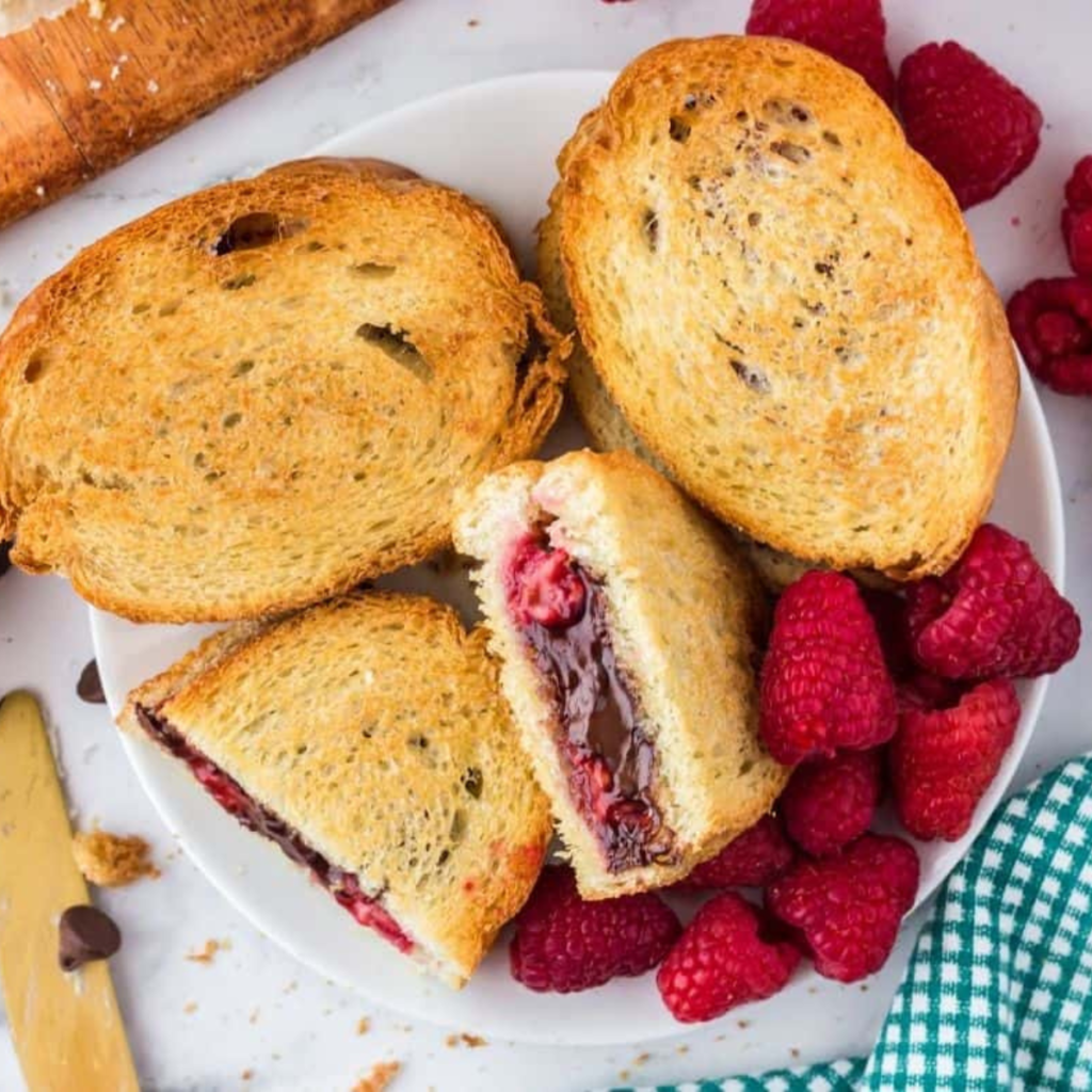 Air fryer chocolate raspberry mascarpone sandwich with melted chocolate and fresh raspberries on toasted bread
