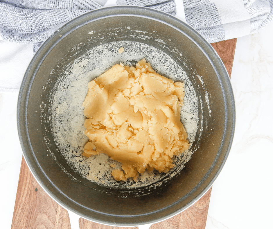 Stirring flour into the saucepan until a smooth dough ball forms, with a thin film on the pan's bottom.
