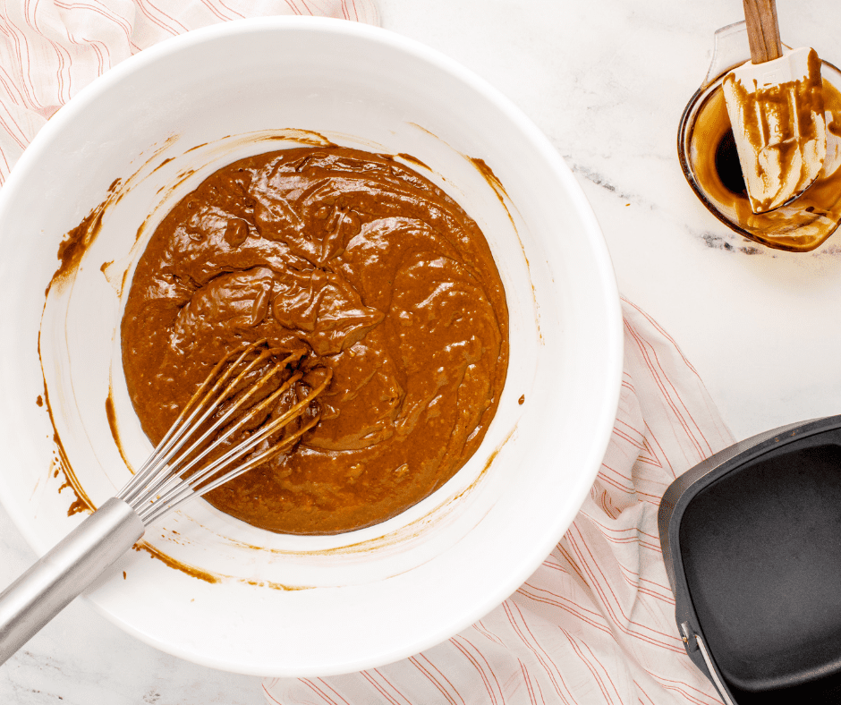 Mixing dry ingredients (flour, baking soda, salt, and ginger) and wet ingredients (egg, molasses, sugar, buttermilk, and butter) to make gingerbread cake batter in a large bowl.