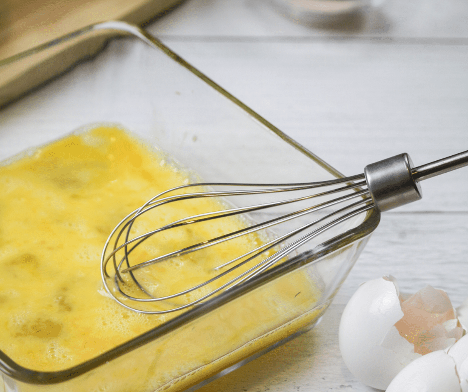Dipping cauliflower florets into flour, beaten eggs, and breadcrumbs for a crispy coating.