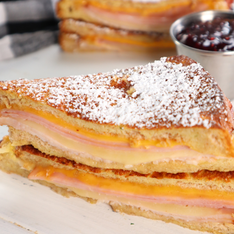 Air fryer Monte Cristo sandwich with ham, turkey, melted cheese, and powdered sugar