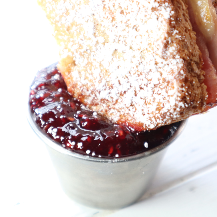 Air fryer Monte Cristo sandwich with ham, turkey, melted cheese, and powdered sugar