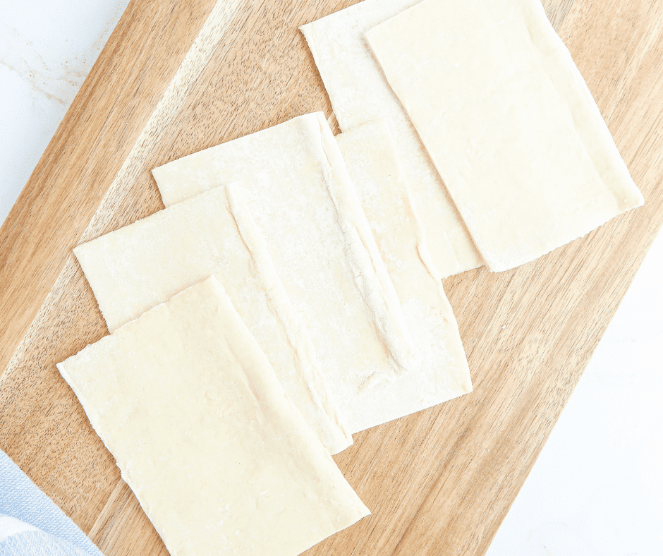 A sheet of puff pastry on a floured surface, ready to cut into rectangles