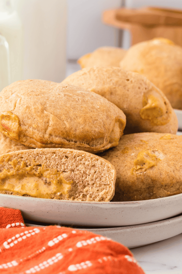 Golden air fryer pumpkin donuts filled with creamy pumpkin custard, served on a plate.