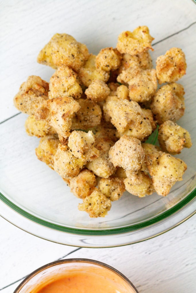 Plate of crispy Air Fryer Bang Bang Cauliflower garnished with green onions and sesame seeds