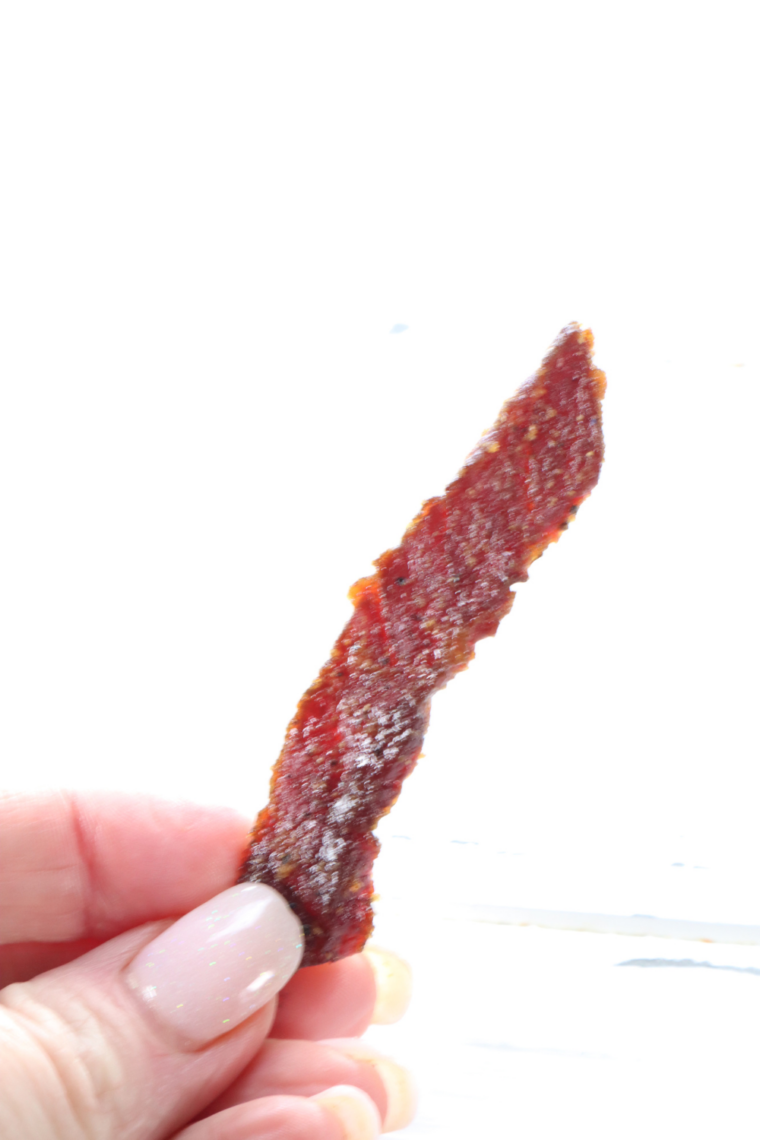 Air fryer beef jerky strips overflowing from a clear glass mason jar — perfect homemade high-protein snack