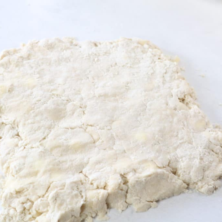 Rolling out biscuit dough to 1-inch thickness and cutting rounds with a biscuit cutter for perfectly shaped biscuits.