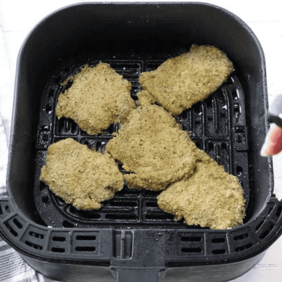 Golden crispy air fryer chicken thigh schnitzel finished in the air fryer basket