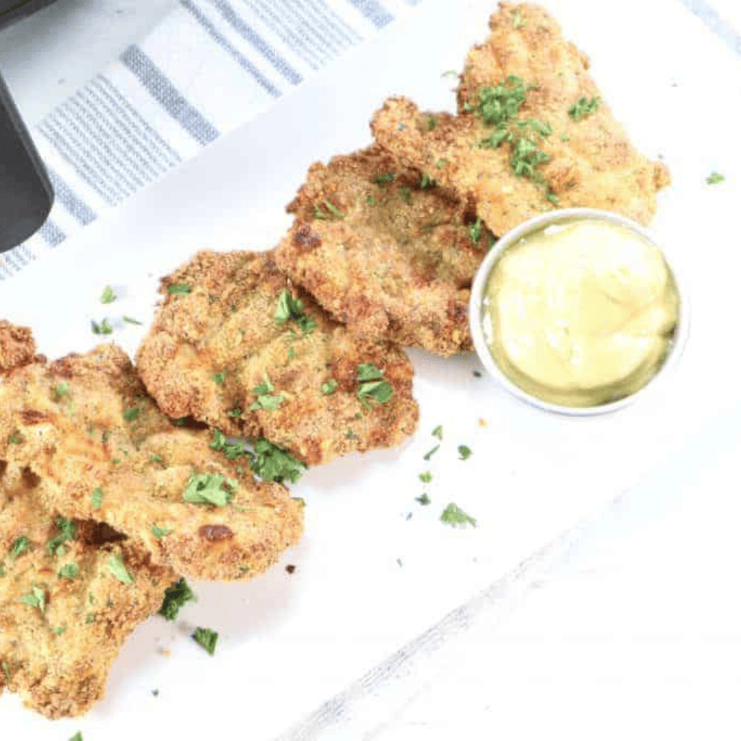 Plate of golden air fryer chicken thigh schnitzel served for dinner
