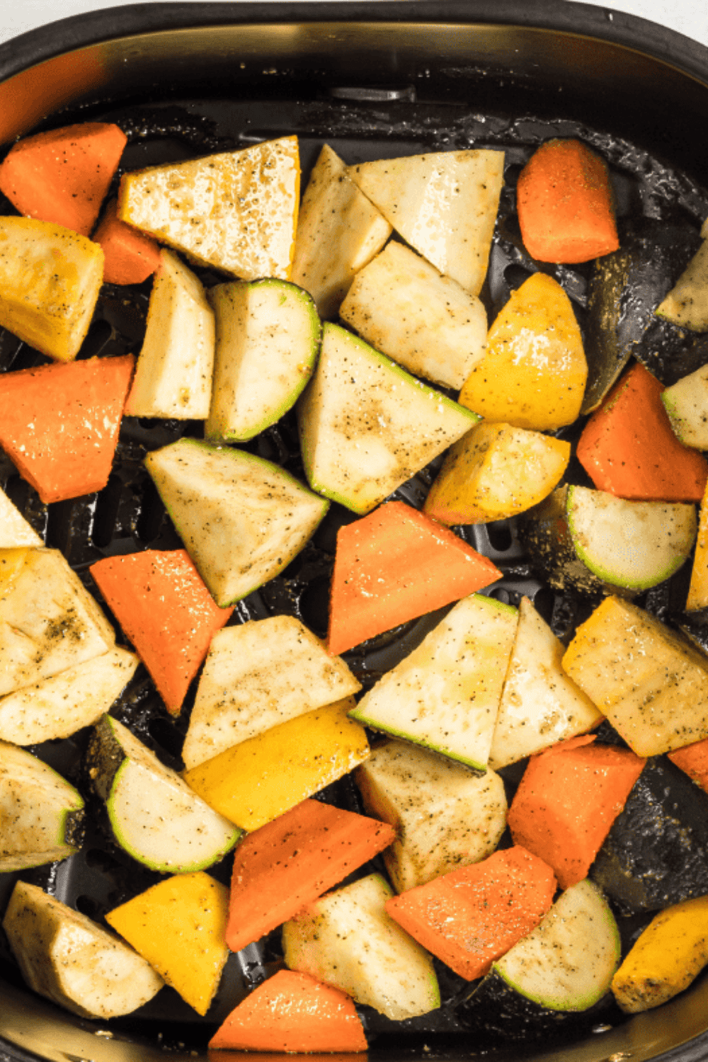 Seasoned vegetables cooking in an air fryer basket set to 400°F for roasting.