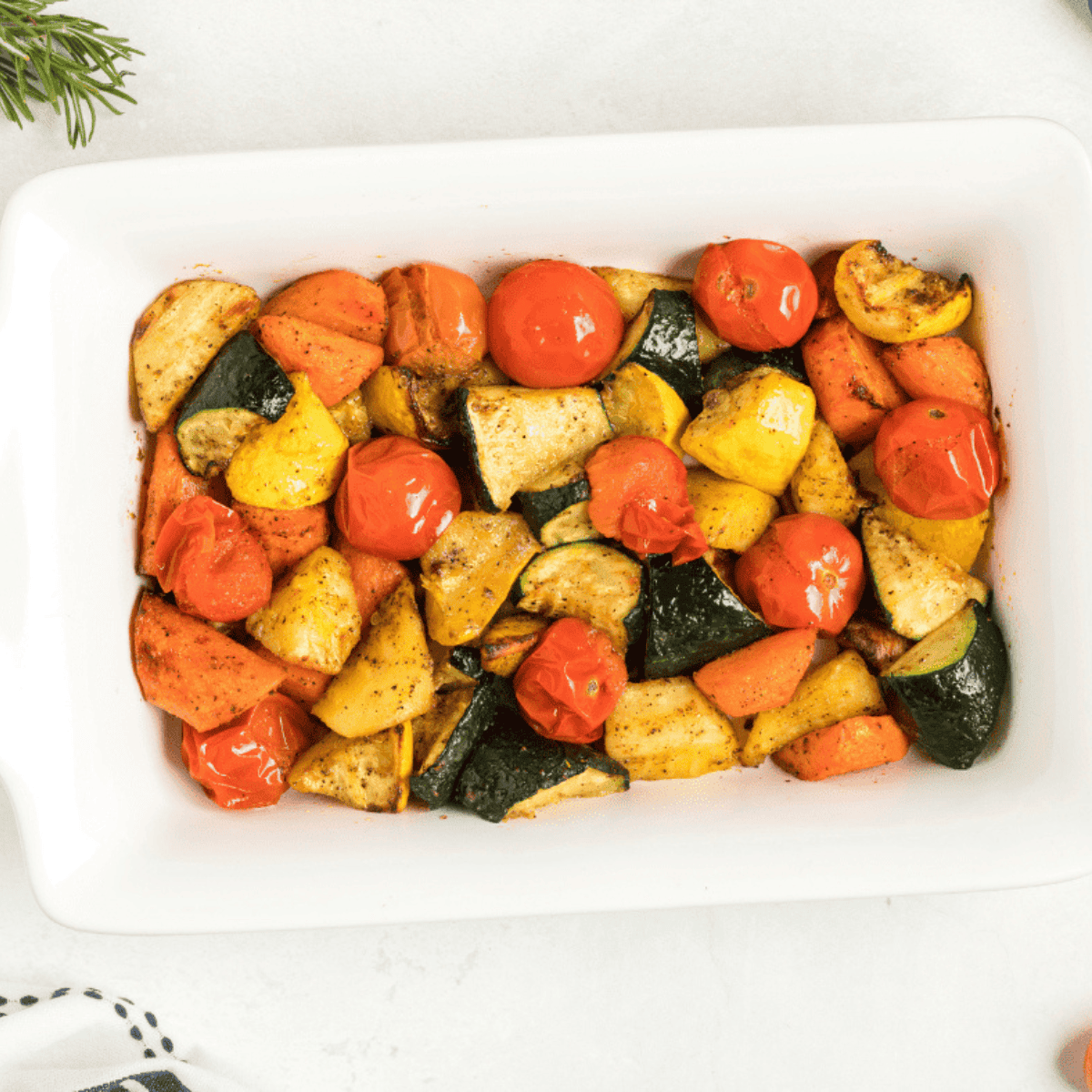 Colorful roasted vegetables cooked in an air fryer, served in a white bowl ready to eat.