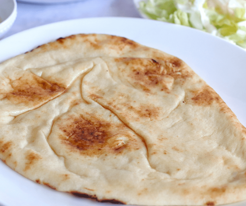 Preheat air fryer to 400°F and brush naan bread with olive oil.