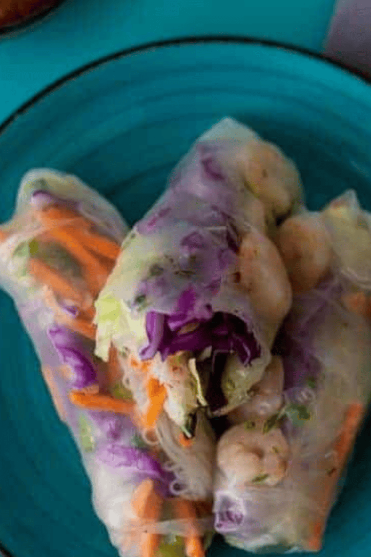 Crispy air fryer rice paper rolls filled with prawns and fresh vegetables, served with dipping sauce.