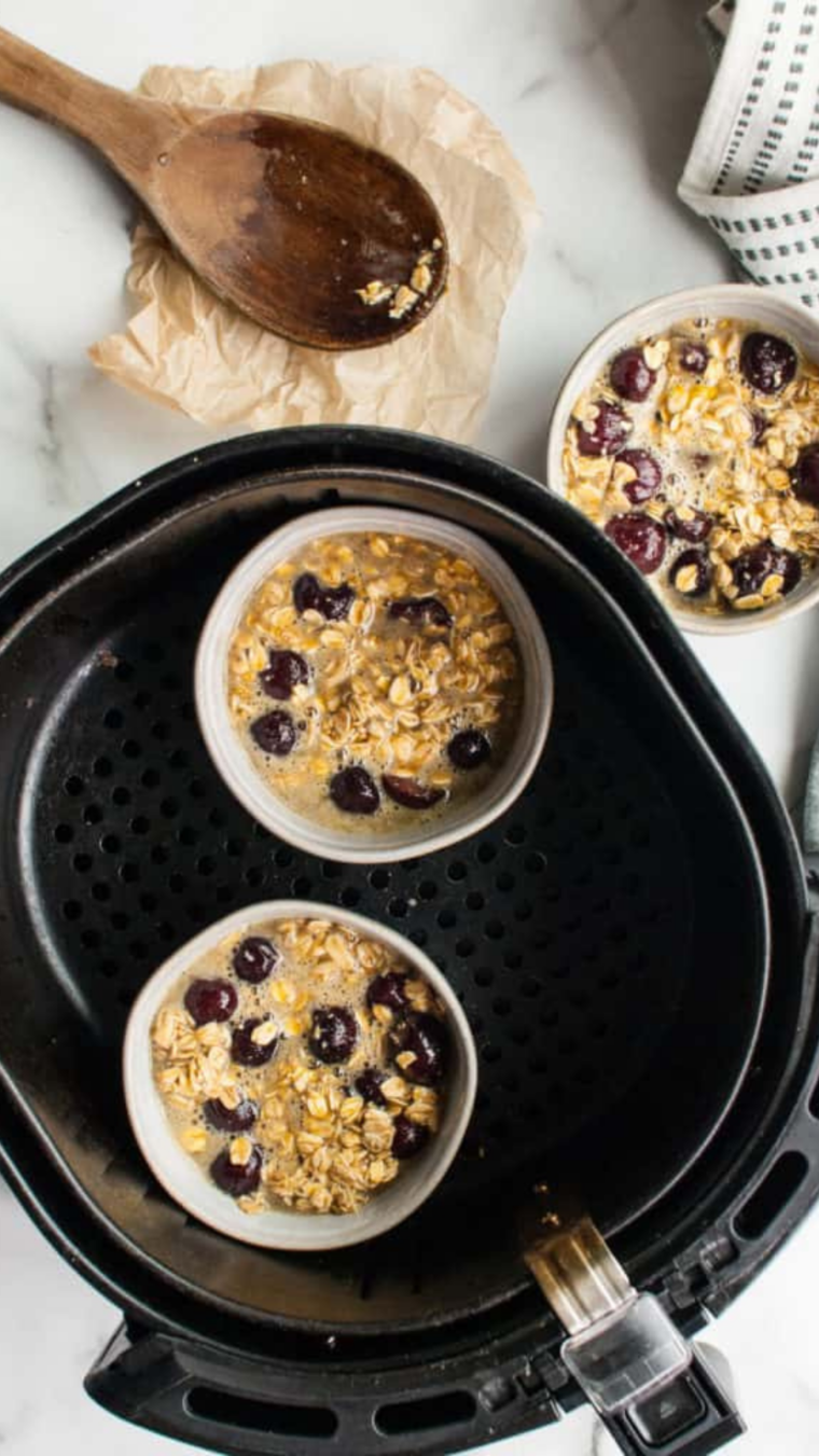 Cherry oatmeal in air fryer basket in oven-safe cups