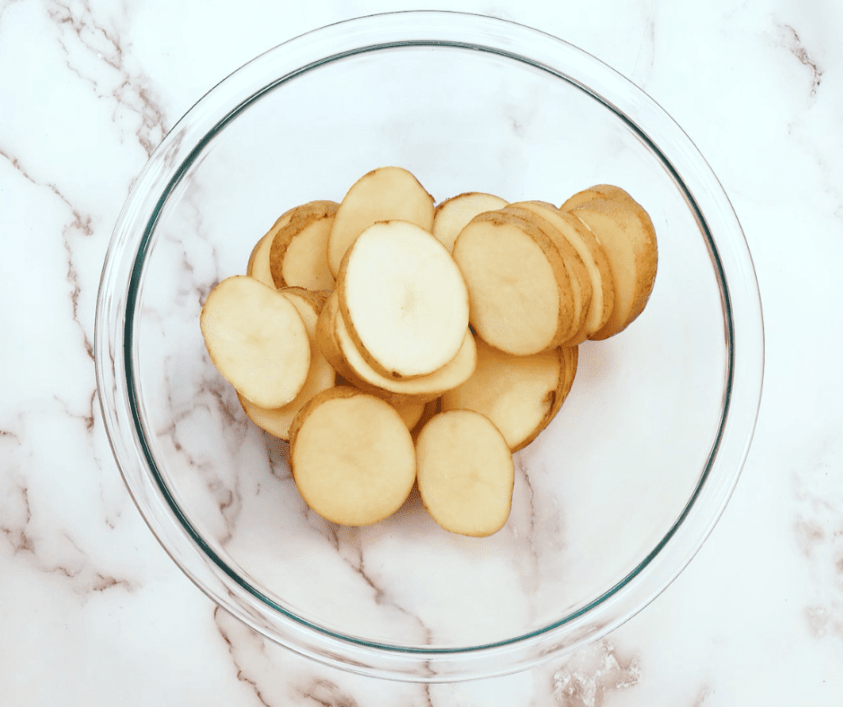 Cutting Potatoes: Diced potatoes being cut on a chopping board, ready to be seasoned.