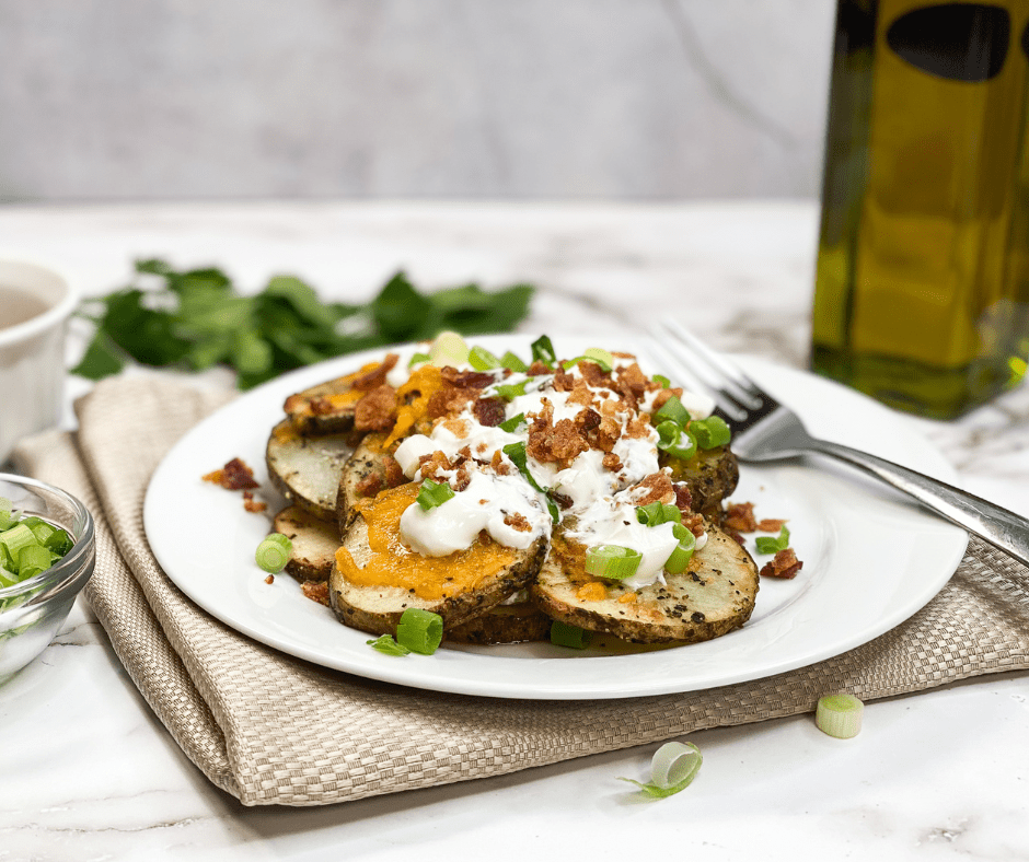 Serving: Air fryer-loaded baked potato foil packs opened to reveal the cooked, melted cheese, and crispy bacon, garnished with fresh chives.