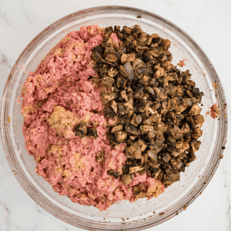 Combining breadcrumbs, milk, eggs, ground turkey, and vegetables in a bow
