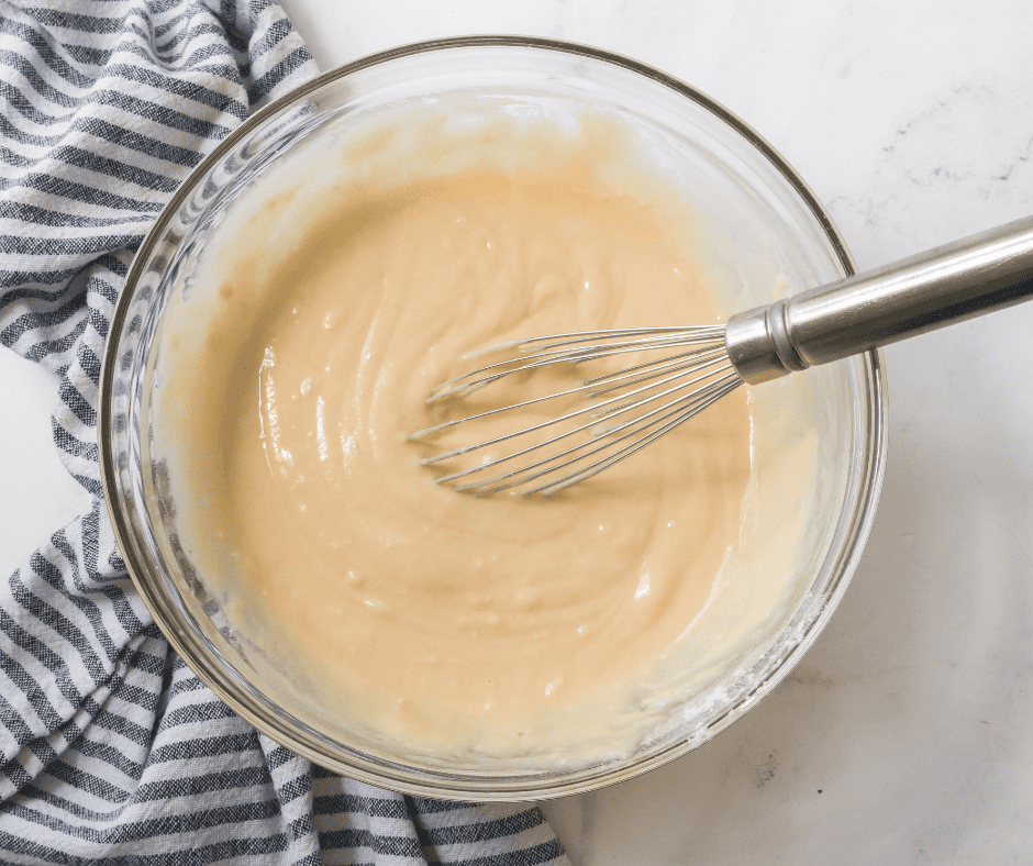 Mixing flour, sugar, baking soda, salt, vanilla extract, oil, and water in a bowl for vanilla cake batter.