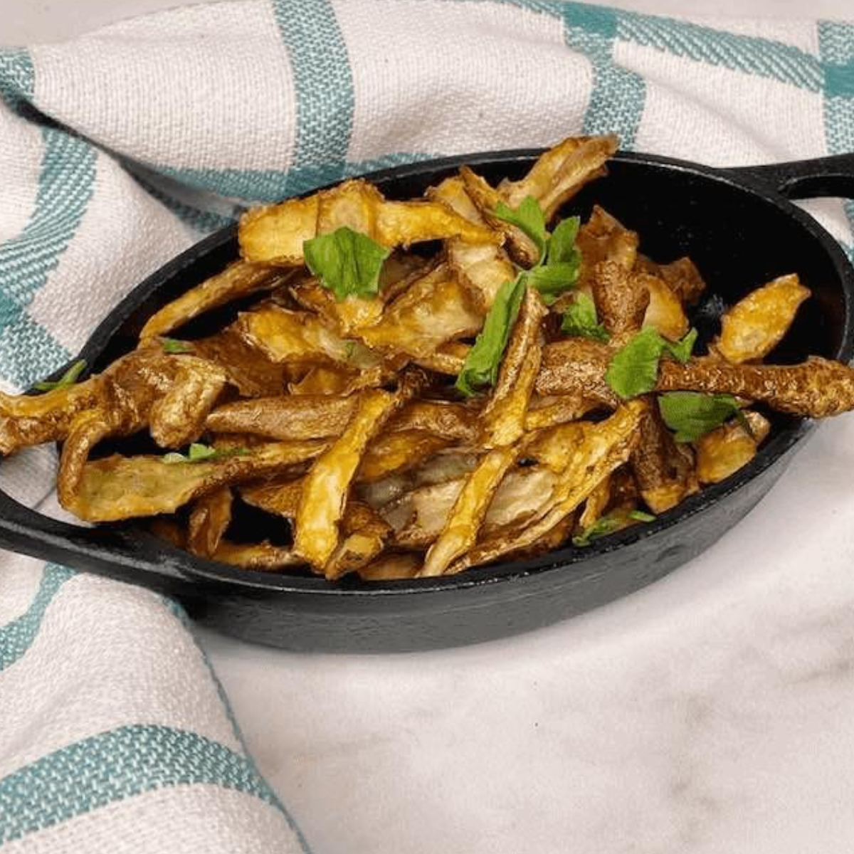 Finished air fryer potato peels garnished and ready to eat