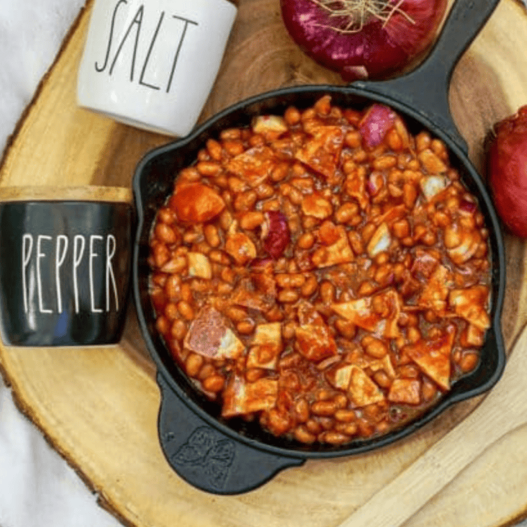 Bowl of KFC-style BBQ baked beans with a rich, smoky sauce, served as a flavorful side dish.