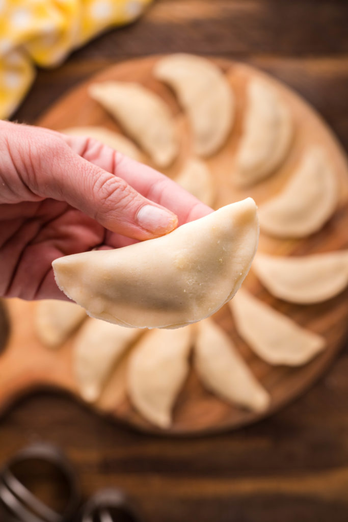 Folding and crimping edges of Air Fryer Breakfast Empanadas.