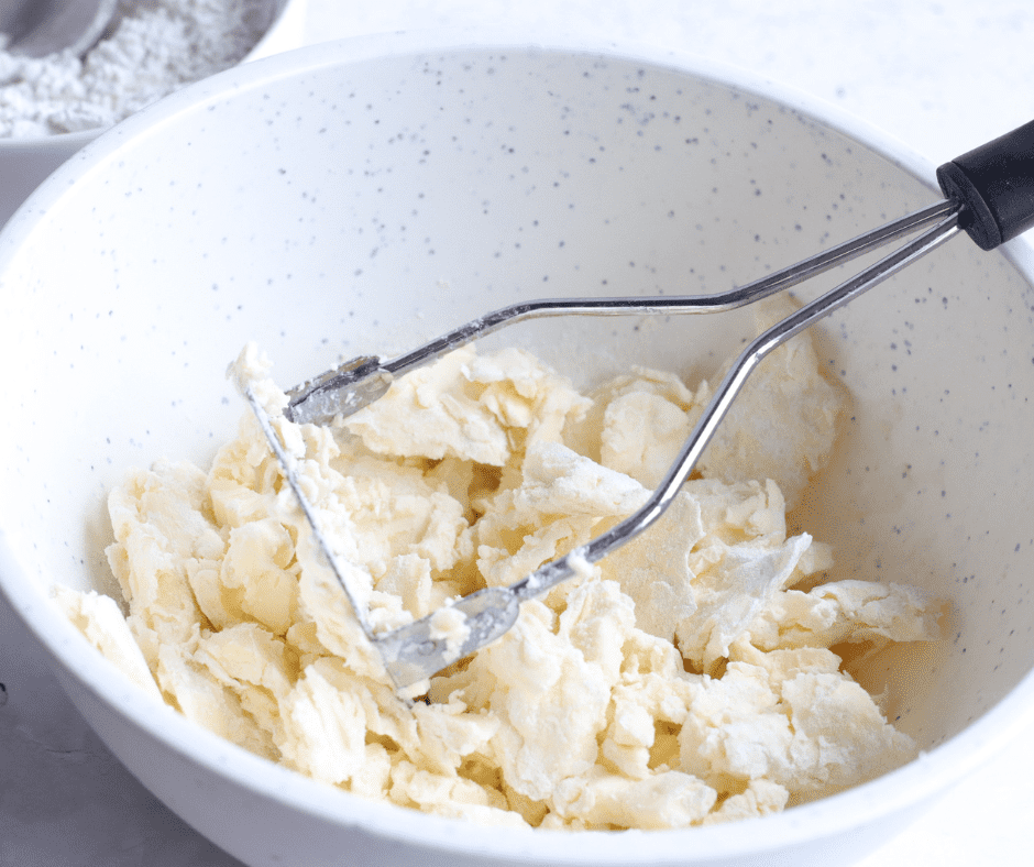 Butter cubes added to a bowl of sugar, flour, salt, and cornstarch for shortbread dough.