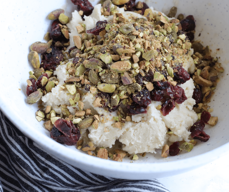 Shortbread dough being mixed with a hand mixer, then cranberries and pistachios folded in.