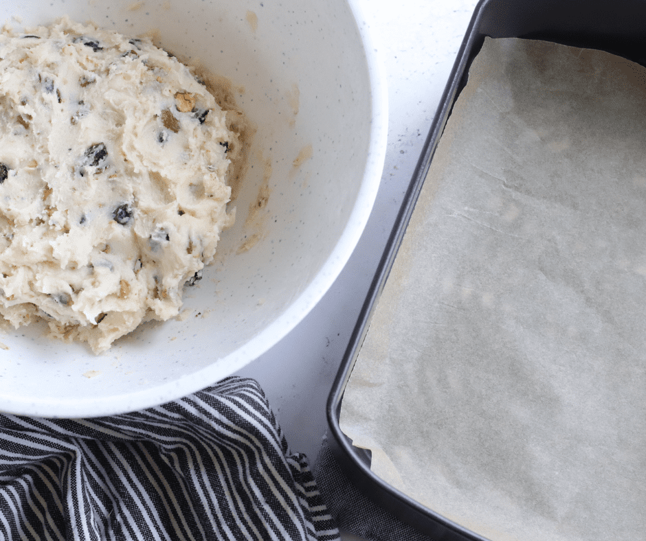 Sticky shortbread dough covered with plastic wrap in the refrigerator to chill.