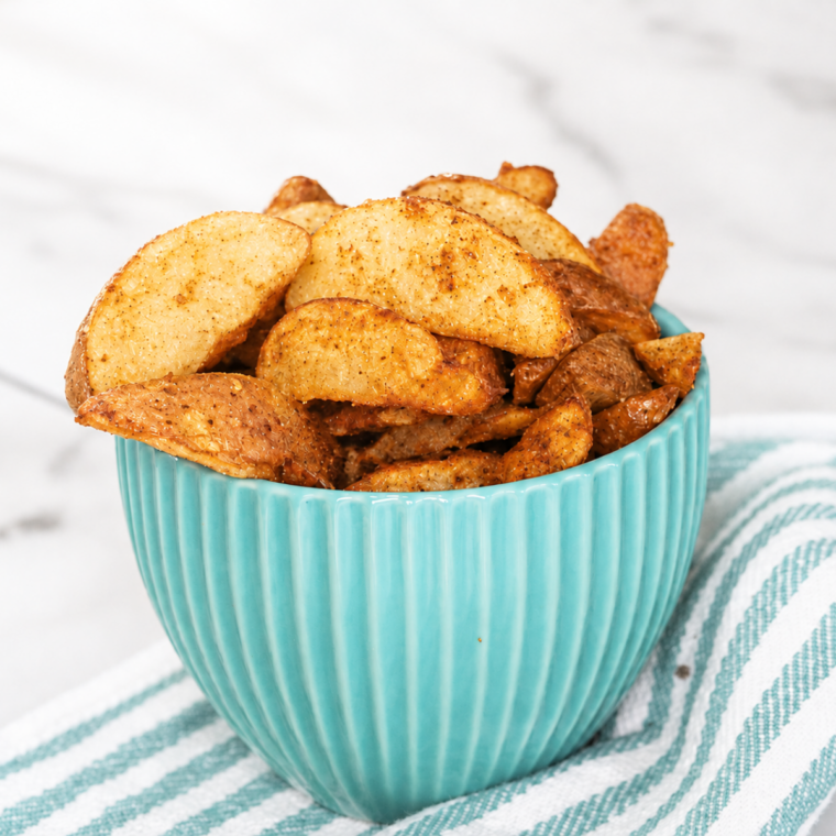 Golden air fryer frozen potato wedges on a plate with dipping sauce
