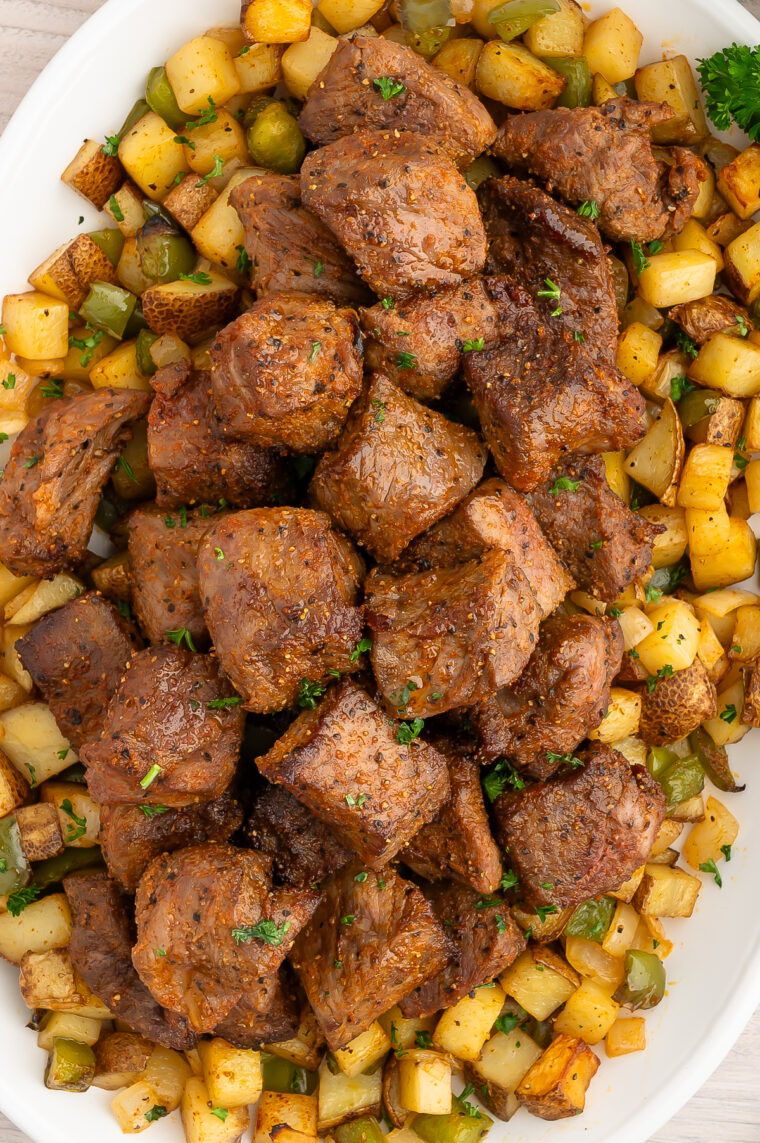 Garlic butter steak bites served over seasoned air fryer potatoes