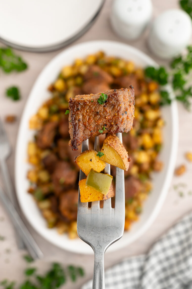 Close-up of tender steak bites alongside golden crispy potatoes
