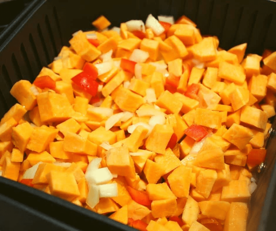 "Pouring sweet potato mixture into the air fryer basket, set to 350°F for 12-15 minutes, shaking occasionally."