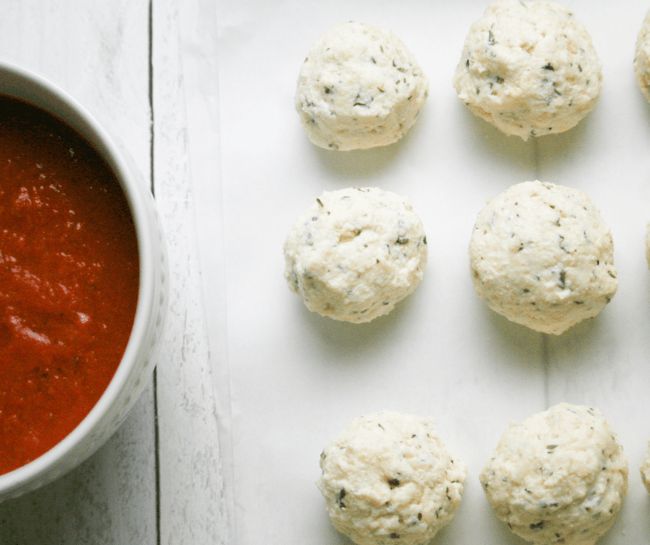 Placing meatballs in pasta sauce, coating them, and air frying at 360°F for 8-12 minutes until firm.